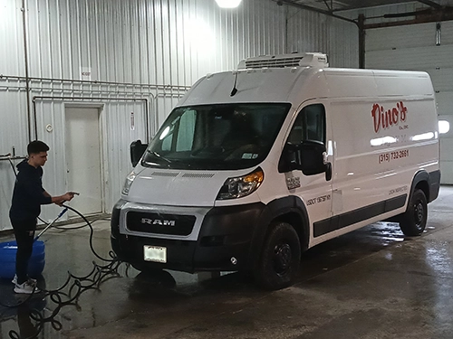 Employee washing Dino's van in wash bay