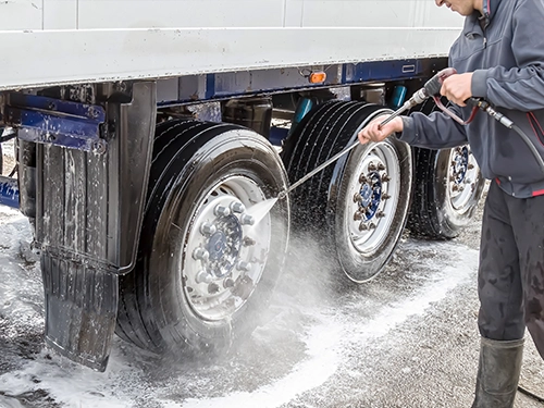 Employee Pressure Washing Trailer Tires